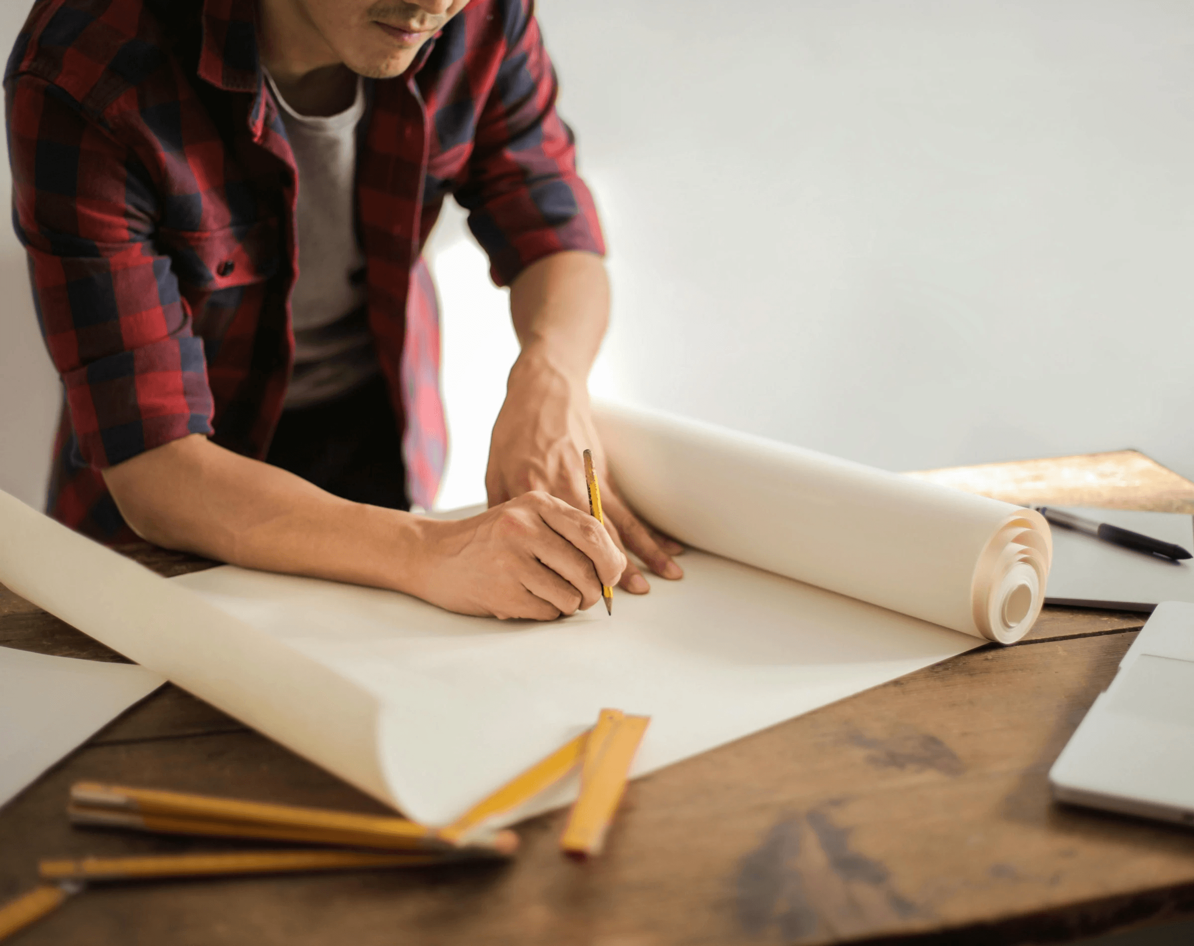 man drawing blueprints